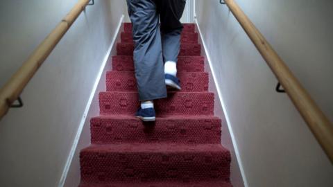 A man walking up stairs in a house