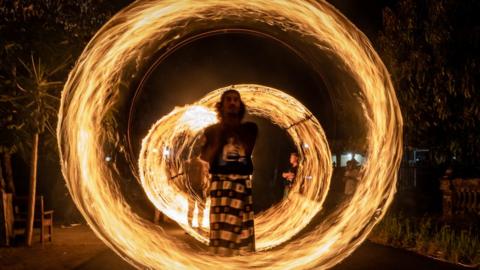 An Indonesian Muslim man plays fire stick during a parade as Muslims celebrate Eid Al-Fitr on June 4, 2018 in Yogyakarta, Indonesia