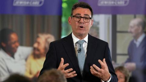 Burnham gesturing with his hands while speaking