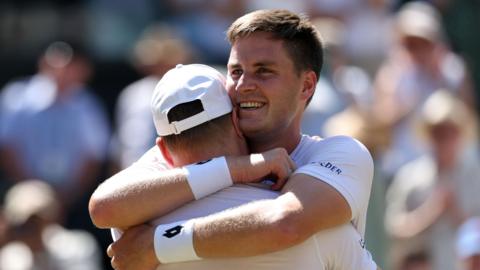 Henry Patten embraces team-mate Harri Heliovaara after winning the Wimbledon men's doubles title