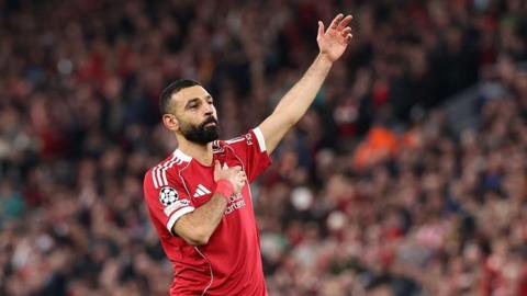 Mohamed Salah touches the Liverpool badge on his shirt as he salutes the crowd after scoring against Galatasaray