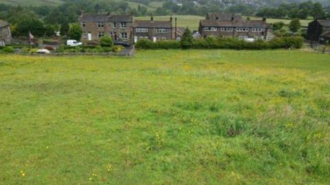 A field with some houses in the background 