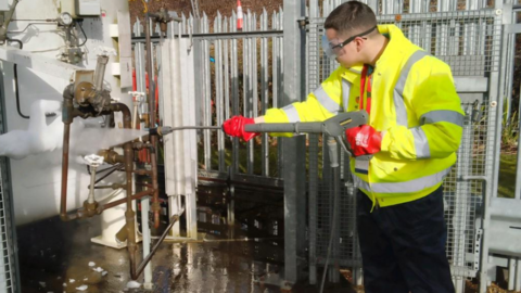 A man involved with the scheme uses a jet machine to clean a piece of equipment