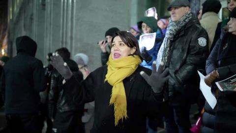 鶹Լ correspondent surrounded by protesters holding photographs