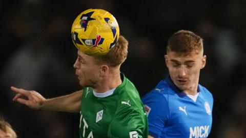 Lewis Fiorini of Stockport County and Ben Woods of Peterborough United