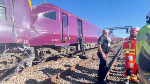 Emergency service workers gather at the scene of a train collision.
