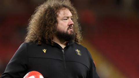 Adam Jones stands with a ball at a Wales training session 