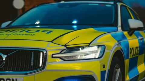 A Northumbria Police car. It is blue and yellow.