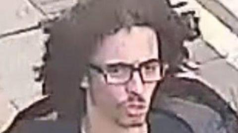 CCTV image of man wearing glasses, wanted in connection to a stabbing