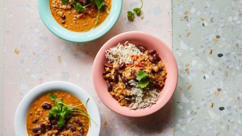 Three bowls of dal and rice on a terrazzo surface 