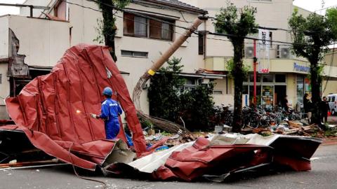 A worker removes debris blown away by strong winds caused by Typhoon Shanshan in Miyazaki on August 29, 2024