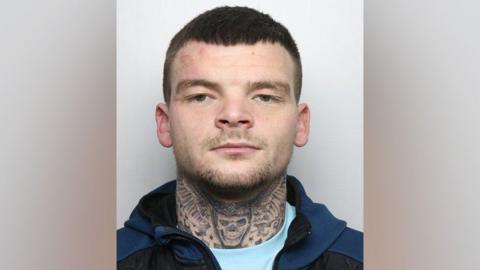 A police custody image of Brandon Brooks, sporting a skull tattoo on his neck