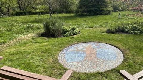 Two park benches overlooking the mosaic depicting a tree of life at Barrow Park