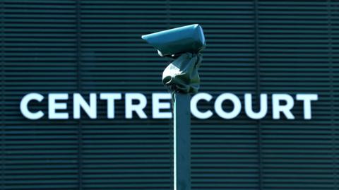 A line camera is pictured with Centre Court in the background