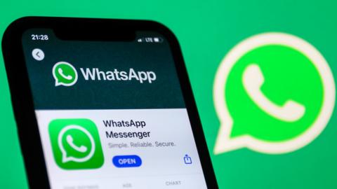 WhatsApp logo on the App Store displayed on a phone screen and WhatsApp logo in the background