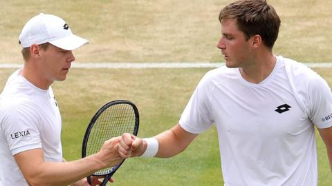 Henry Patten and Harri Heliovaara bump fists after winning a point at Wimbledon