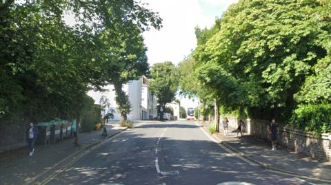 A leafy city street on a sunny day. 