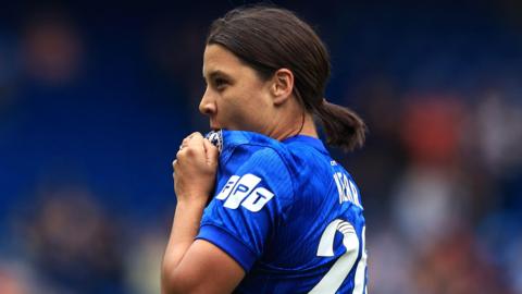 A photo of Sam Kerr kissing the Chelsea badge
