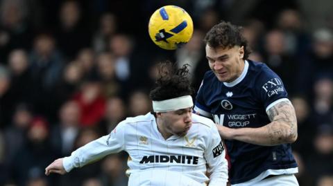 Millwall defender Jake Cooper (5) and Sheffield United midfielder Callum O'Hare (10) challenge for a header