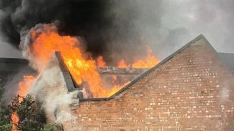 A fire at a building with smoke rising into the sky