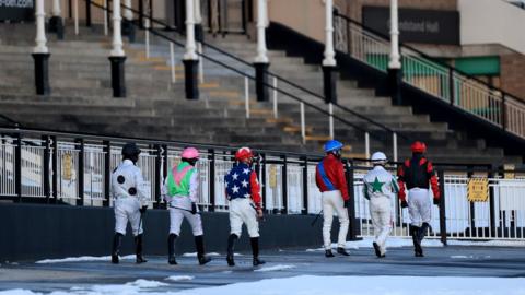 Jockeys make their way out ahead of the Ladbrokes Home Of The Odds Boost Fillies" Novice Stakes at Newcastle racecourse on 11 February
