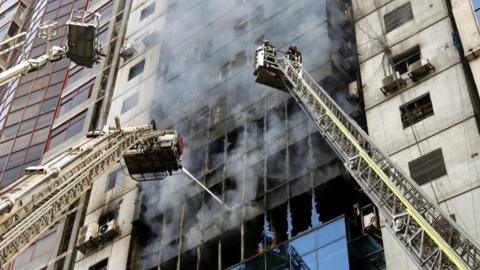 Firefighters try to extinguish a fire that broke out at a high-rise building in Banani area of Dhaka, Bangladesh, 28 March 2019