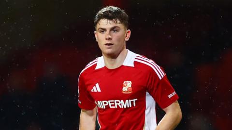 Gavin Kilkenny standing on the pitch during a match for Swindon