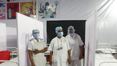 Nurses wear PPE on a ward in India