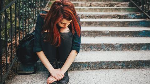 Young woman sat on steps