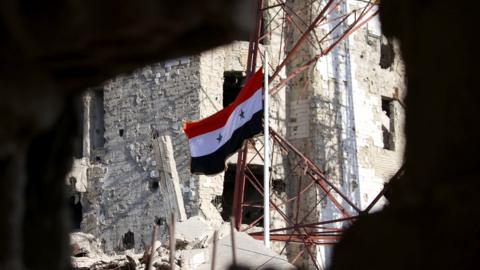 Syrian flag seen through hole in damaged building (file photo)