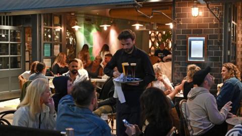 A waiter serves drinks to diners at the Old Compton in the Soho area of London