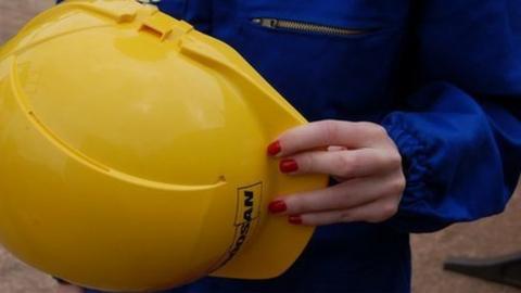 Nail varnished hand with hard hat