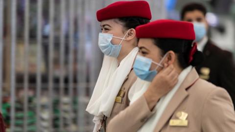 Crew members from Emirates airline are seen leaving Hong Kong international airport.