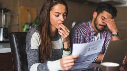 A man and woman worrying about paying a bill