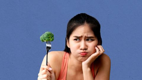 Woman frowning at broccoli