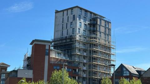 The tower of Regatta quay with scaffolding along part of it.  