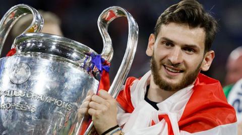 Khvicha Kvaratskhelia holding the Champions League trophy