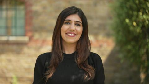 Lovina Shenoy in a black dress. She has brown hair. 