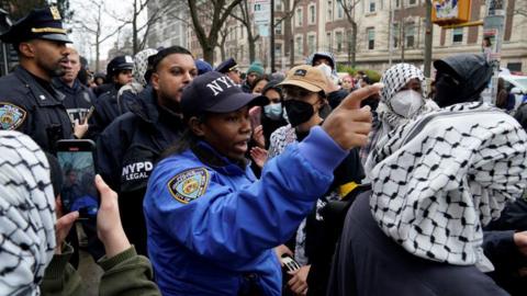 Police officer at Columbia University alongside students. 