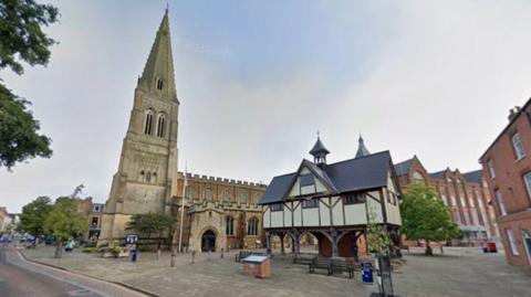 The centre of Market Harborough with its distinctive timber-framed former grammar school building and the St Dionysius' Church