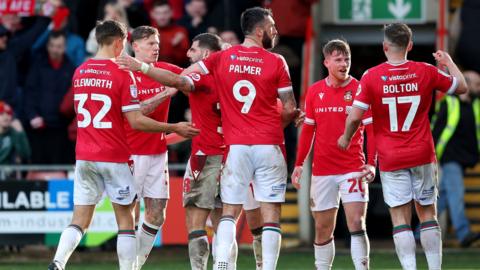 Wrexham players celebrate Paul Mullin's second goal against Mansfield Town