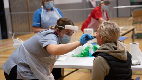 A nurse administers a lateral flow Covid-19 test