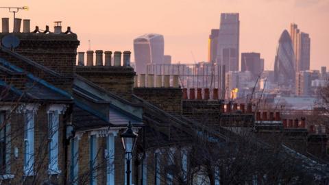 File image showing a row of rooftops with London's city skyscrapers in the background