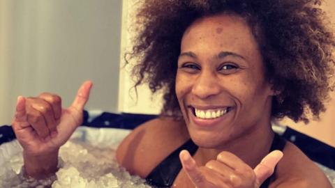 Asmaa Niang gives the thumbs up as she relaxes in an ice bath.