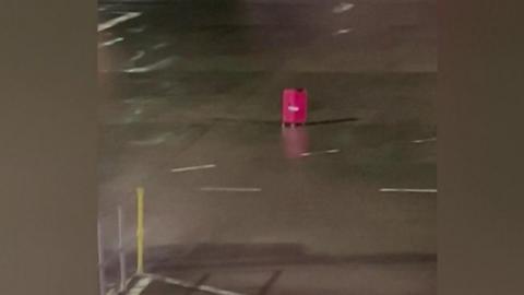 Pink suitcase on airplane ramp at Edinburgh airport