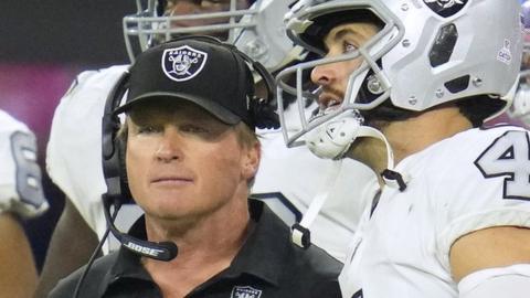 Jon Gruden speaks with Las Vegas Raiders quarterback Derek Carr