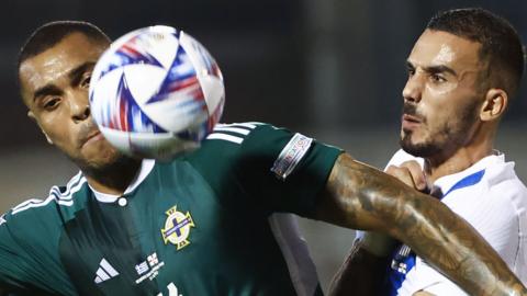 NI striker Josh Magennis comes under pressure against Greece