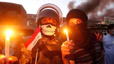 Protesters hold candles near a government building in Iraq's Basra, 6 September 2018