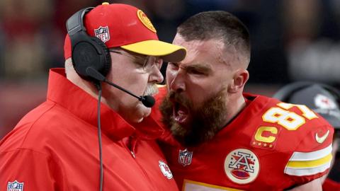 Travis Kelce #87 of the Kansas City Chiefs reacts to head coach Andy Reid