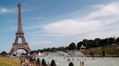 People bathe in the Trocadero Fountain near the Eiffel Tower in Paris during a heatwave on June 28, 2019.